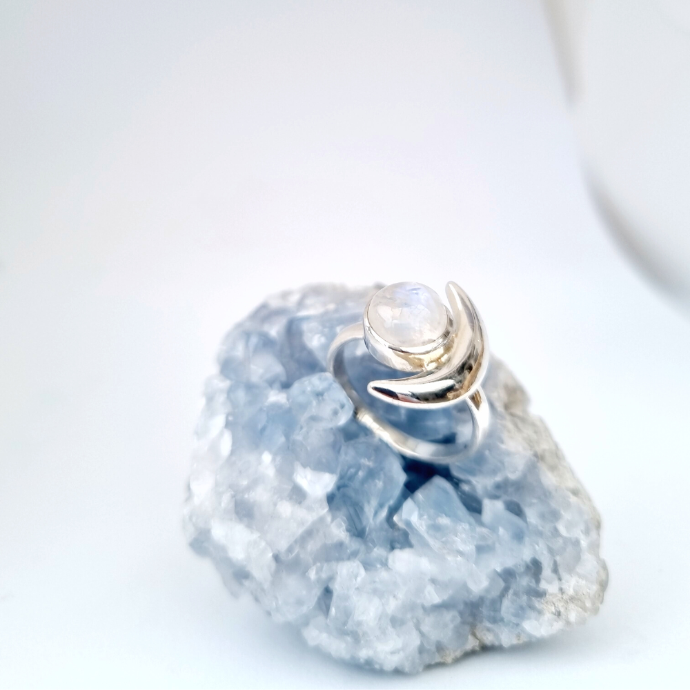Moonstone crystal ring sitting on crystal cluster